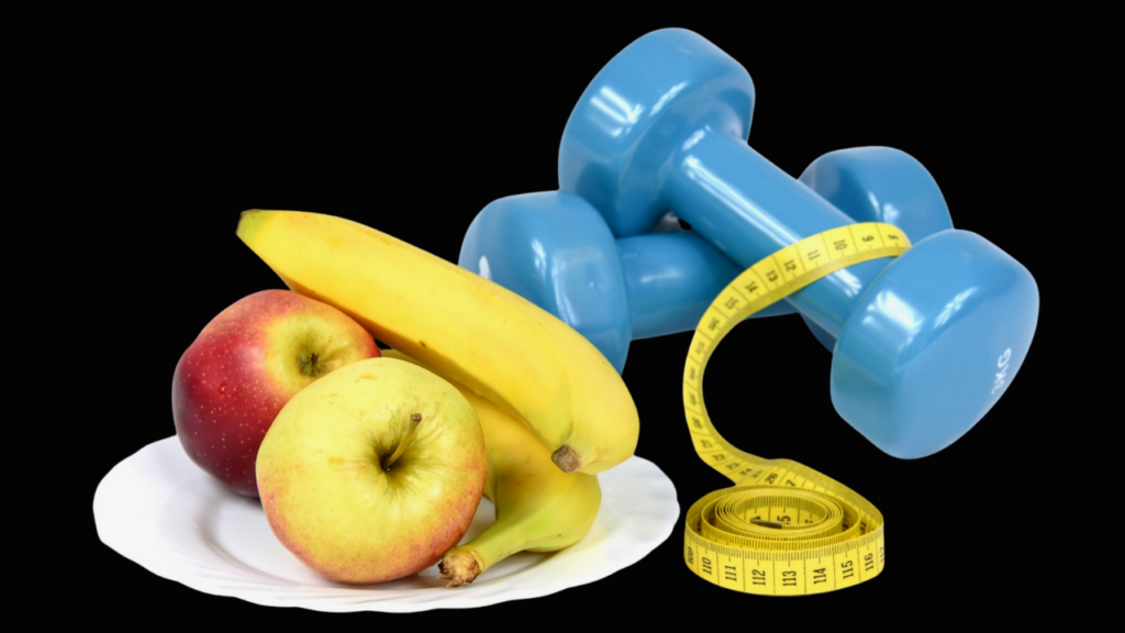 A balanced concept of health and fitness with fresh fruits on a plate, a pair of blue dumbbells, and a yellow measuring tape, all set against a black background.