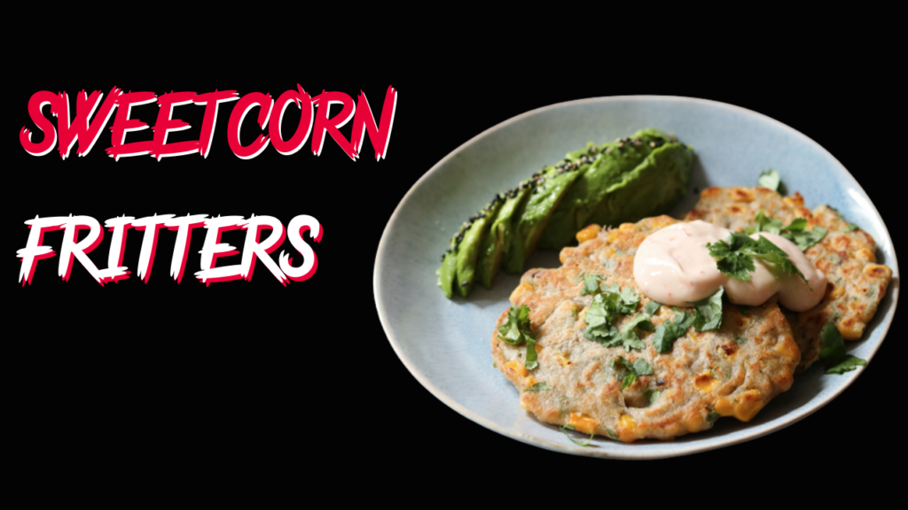 Delicious sweetcorn fritters served with a creamy sauce and a side of sliced avocado, perfect for a savory breakfast or snack.