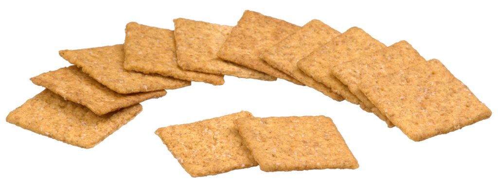 A group of whole wheat crackers neatly arranged and overlapping each other on a white background.