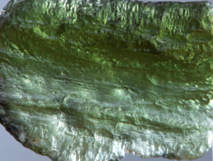 Close-up view of a textured green mineral with a glassy luster.