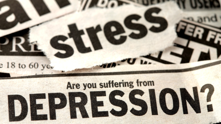 A close-up of torn newspaper headlines focusing on mental health, with a prominent question "are you suffering from depression?" indicating an article about depression well-being.