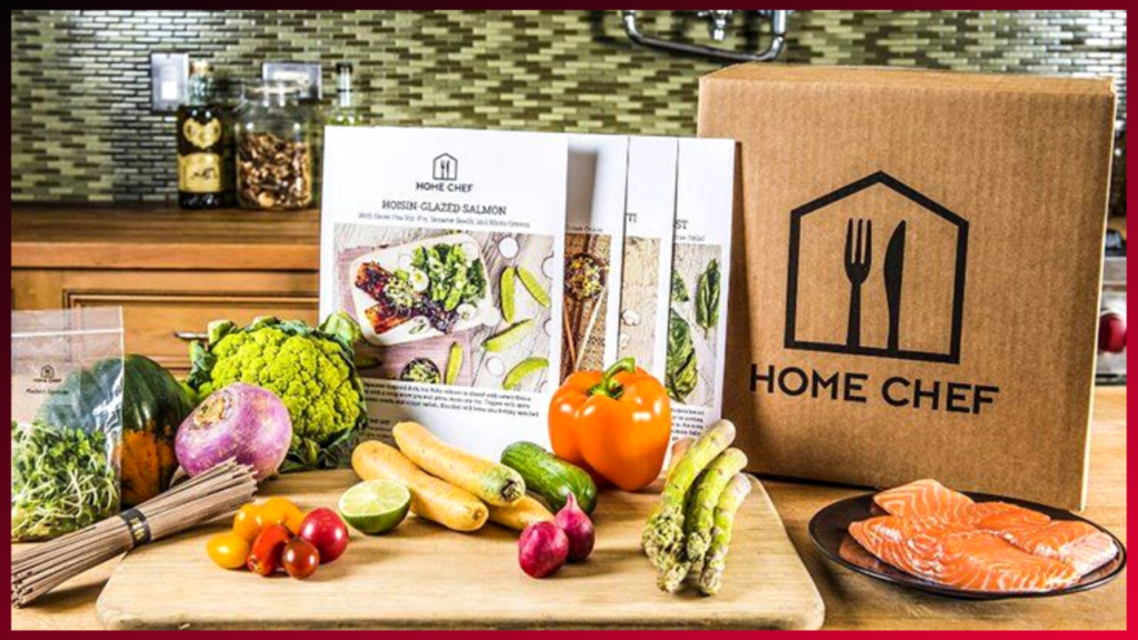 A colorful array of fresh vegetables and a salmon fillet laid out on a wooden cutting board, alongside a Home Chef meal kit box and recipe card, ready for a home cooking experience.