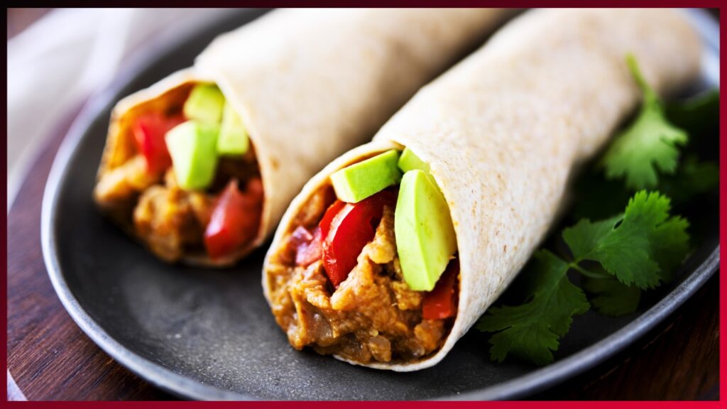 Savory chicken burritos with fresh avocado and tomato nestled in soft tortillas, ready to tantalize the taste buds.