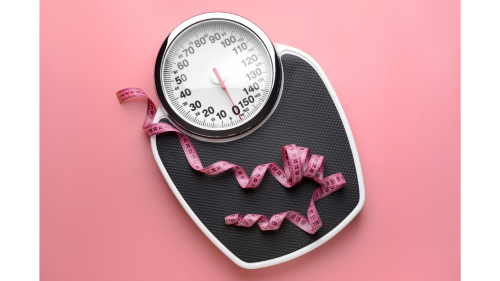 A bathroom scale with a measuring tape loosely coiled atop it, set against a pink background, possibly symbolizing weight management and fitness tracking.